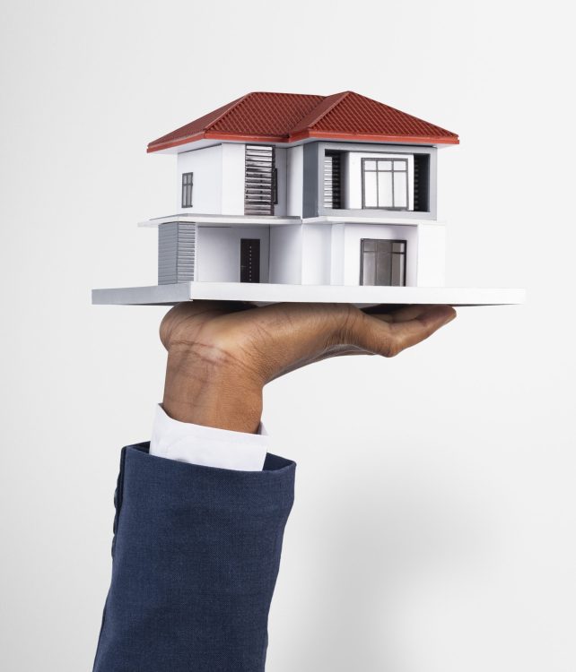 Hand holding house real estate and property model
