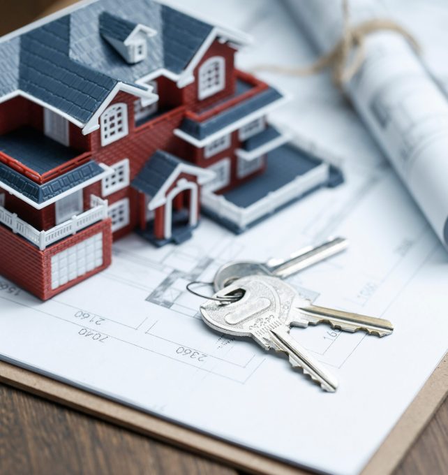 Villa house model, key and drawing on retro desktop (real estate sale concept)